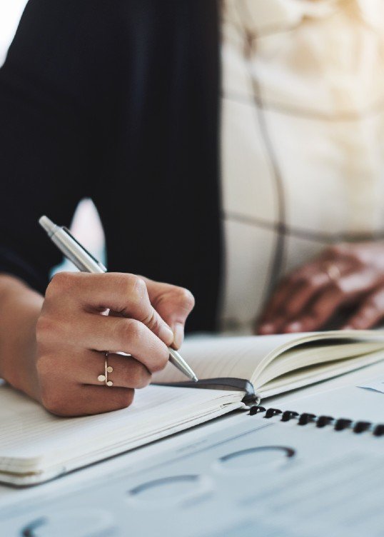 women is writing something in her notebook